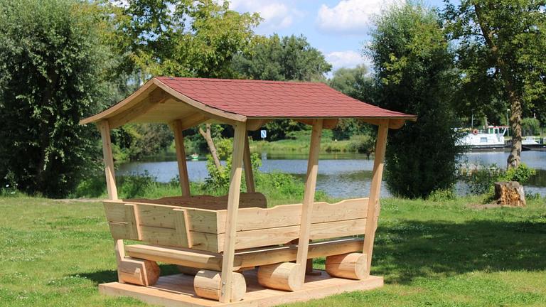 Gartenlaube. Überdachte Sitzgarnitur. Krongartmöbel.