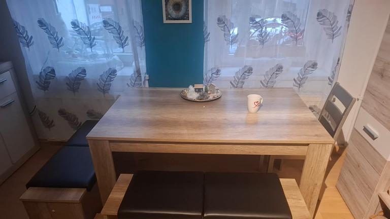 Wohnwand und esstisch mit sitzbänken