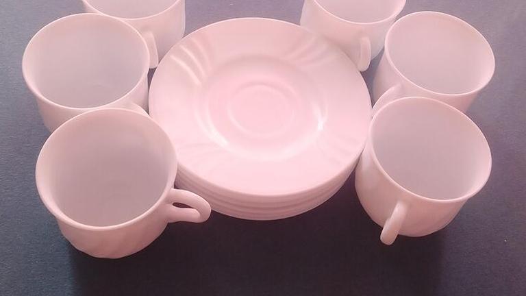 Das Bild zeigt ein Set aus sechs weißen Kaffeetassen oder Teetassen